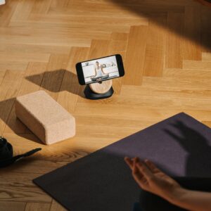 A serene home yoga setup with phone streaming class and mat.