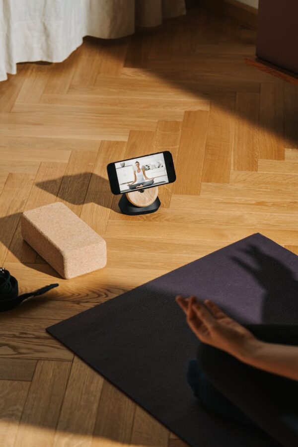 A serene home yoga setup with phone streaming class and mat.